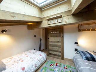 Charming attic bedroom with twin beds, perfect for kids.