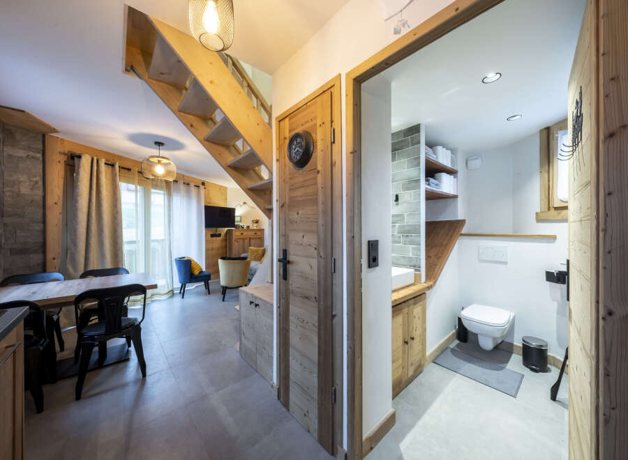 This stunning chalet boasts a spacious open-plan living area with a cozy seating arrangement and a modern kitchen.