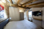 Cozy chalet bedroom with exposed wooden beams and a comfortable bed.