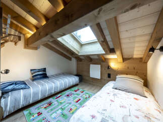 Charming attic bedroom with two twin beds, perfect for kids.