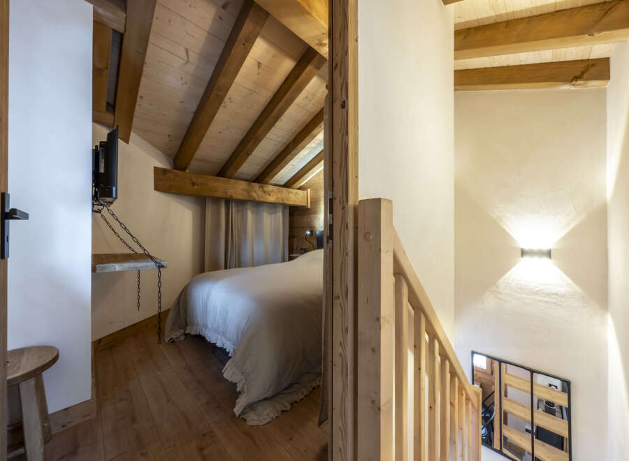 Cozy chalet bedroom with wooden beams and rustic charm.