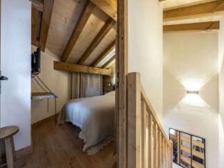 Cozy chalet bedroom with wooden beams and rustic charm.