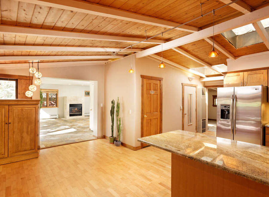This stunning home boasts a gorgeous wood-beamed ceiling and skylights, creating an open and airy atmosphere.