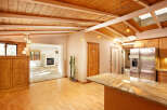 This stunning home boasts a gorgeous wood-beamed ceiling and skylights, creating an open and airy atmosphere.