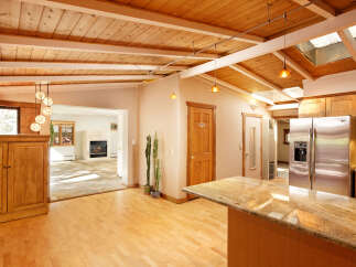 This stunning home boasts a gorgeous wood-beamed ceiling and skylights, creating an open and airy atmosphere.