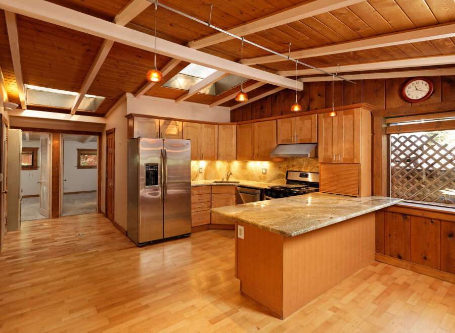 This charming kitchen boasts a vaulted wood ceiling with skylights, creating a bright and airy atmosphere.