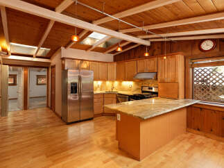 This charming kitchen boasts a vaulted wood ceiling with skylights, creating a bright and airy atmosphere.