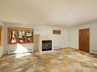 This stunning property boasts a spacious living area with a cozy fireplace, perfect for relaxing evenings.
