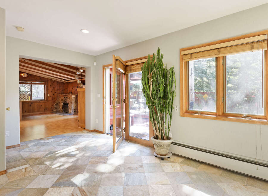 This stunning home boasts a spacious sunlit interior with hardwood floors and a cozy stone fireplace.