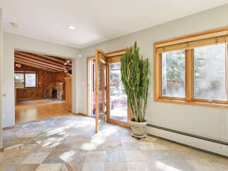 This stunning home boasts a spacious sunlit interior with hardwood floors and a cozy stone fireplace.