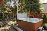 Relax and rejuvenate in your private hot tub, nestled amidst a serene wooded backdrop.