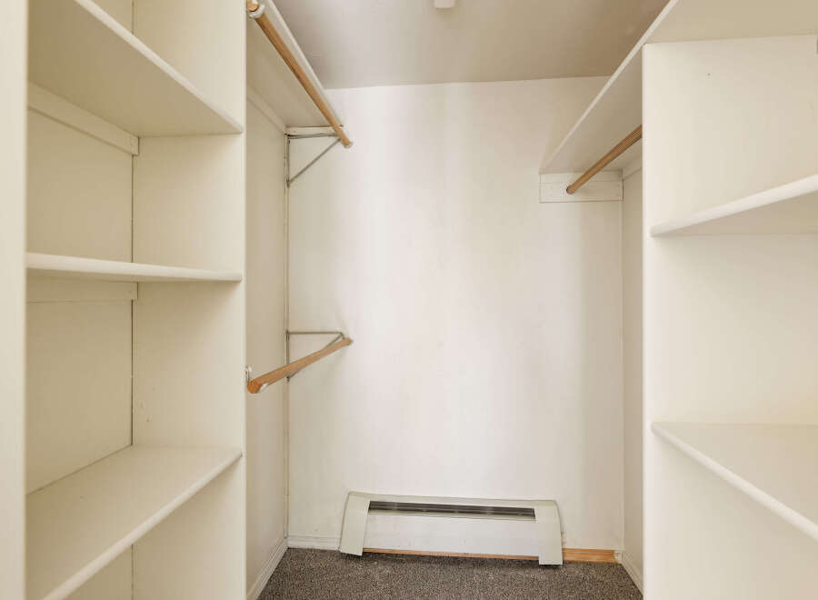 Spacious closet with ample shelving and hanging rods, providing convenient storage solutions.