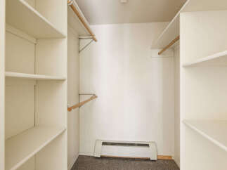 Spacious closet with ample shelving and hanging rods, providing convenient storage solutions.