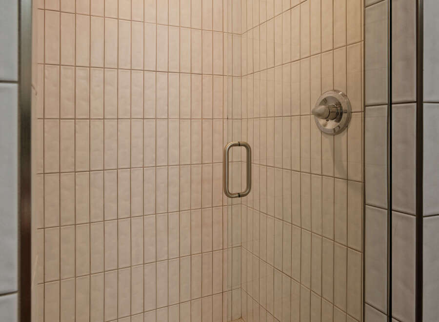 This stunning bathroom boasts a spacious shower with sleek glass enclosure and modern fixtures.
