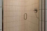 This stunning bathroom boasts a spacious shower with sleek glass enclosure and modern fixtures.