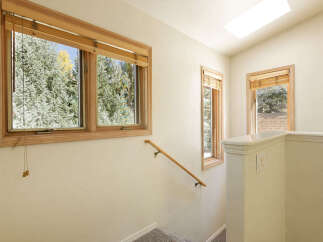 This charming home boasts a bright and airy interior with large windows offering stunning views of the surrounding landscape.