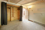 Cozy bedroom with built-in closet featuring wood paneling and shelving.