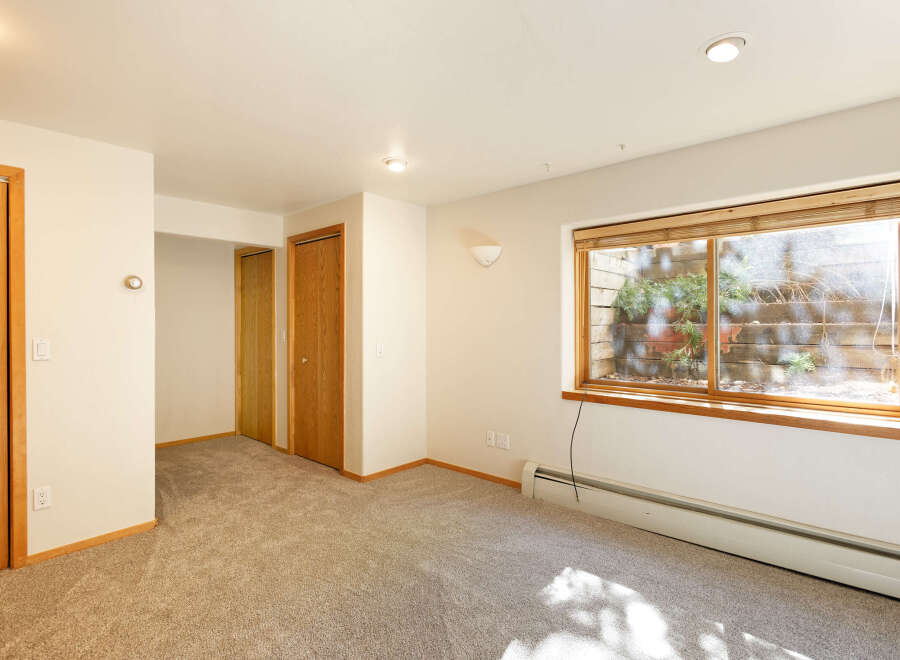 Spacious room with neutral walls and carpet flooring.