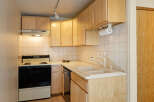 Cozy kitchen with light wood cabinets and white tile backsplash.