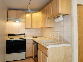 Cozy kitchen with light wood cabinets and white tile backsplash.