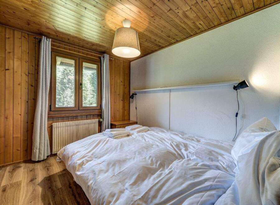 Cozy bedroom with wooden paneling and a warm, inviting atmosphere.