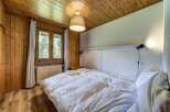 Cozy bedroom with wooden paneling and a warm, inviting atmosphere.