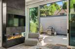 This stunning home boasts a modern fireplace and large sliding glass doors that open to a private patio with a built-in grill.