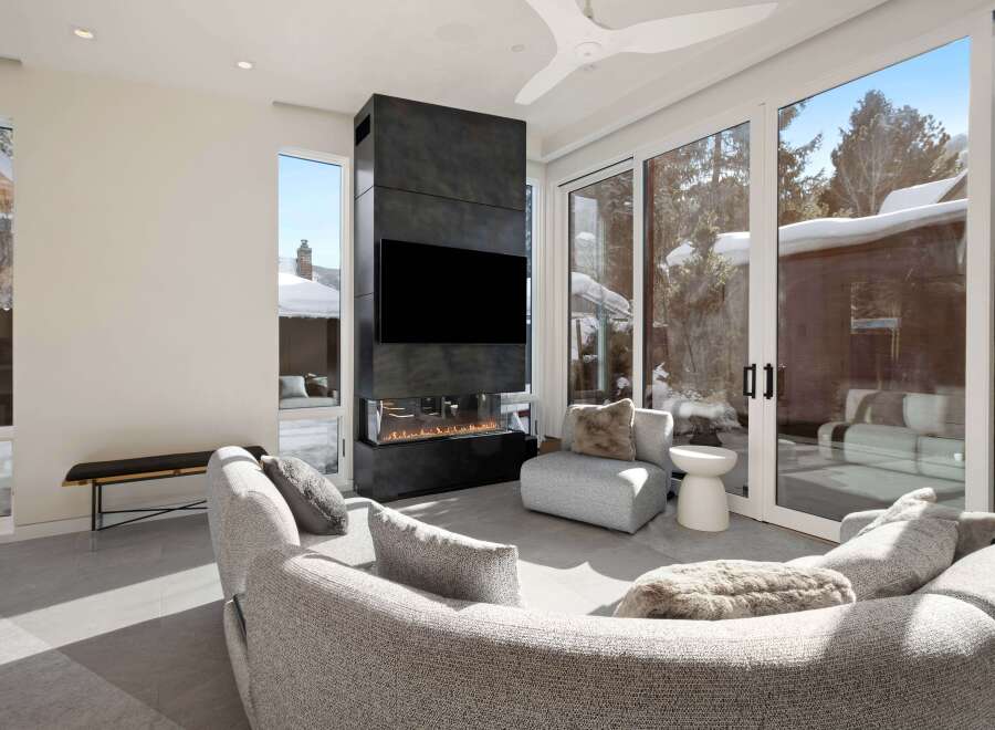 This stunning home boasts a spacious living area with floor-to-ceiling windows offering breathtaking views and ample natural light.