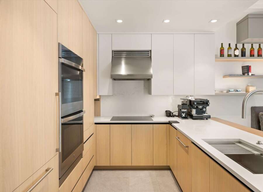 This stunning kitchen boasts sleek stainless steel appliances and light oak cabinetry, creating a modern and sophisticated atmosphere.