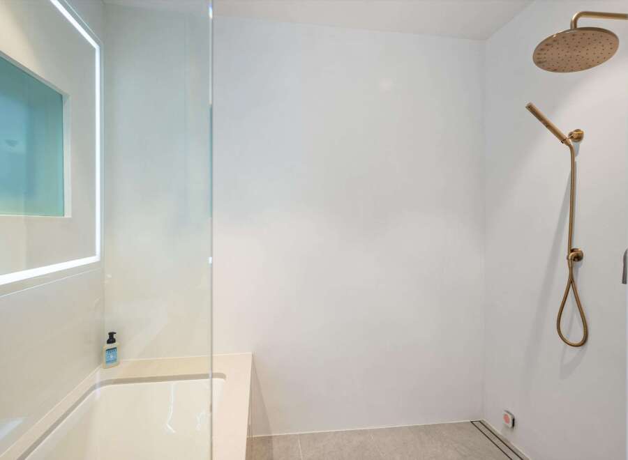 Modern bathroom with a sleek, frameless glass shower enclosure and a luxurious rainfall shower head.