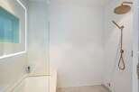 Modern bathroom with a sleek, frameless glass shower enclosure and a luxurious rainfall shower head.