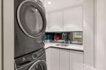 This stunning laundry room boasts modern, sleek appliances and ample storage.