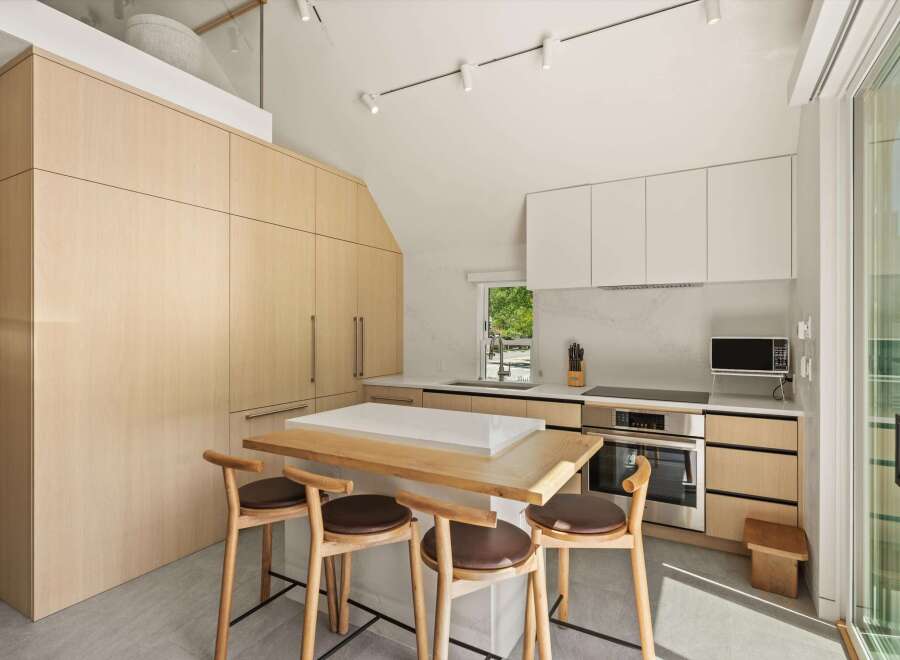 This stunning kitchen boasts a modern design with light wood cabinets and white countertops.