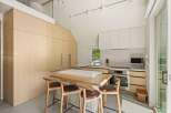 This stunning kitchen boasts a modern design with light wood cabinets and white countertops.