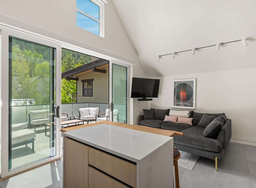 Modern living space with floor-to-ceiling sliding glass doors leading to a private balcony, offering stunning views.