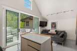 Modern living space with floor-to-ceiling sliding glass doors leading to a private balcony, offering stunning views.