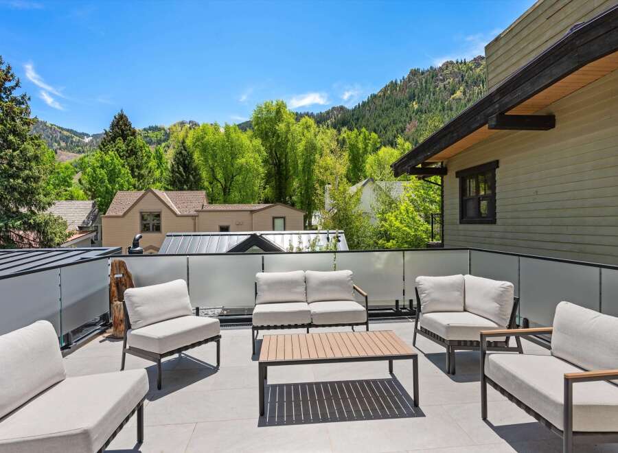 This stunning rooftop deck boasts breathtaking mountain views and luxurious outdoor furniture, perfect for relaxing and entertaining.