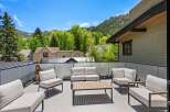 This stunning rooftop deck boasts breathtaking mountain views and luxurious outdoor furniture, perfect for relaxing and entertaining.