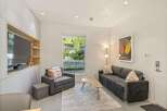 Modern living room with built-in entertainment center, comfortable sofa, and large window offering natural light.