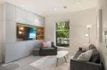 Modern living room with built-in entertainment center and large window overlooking backyard.
