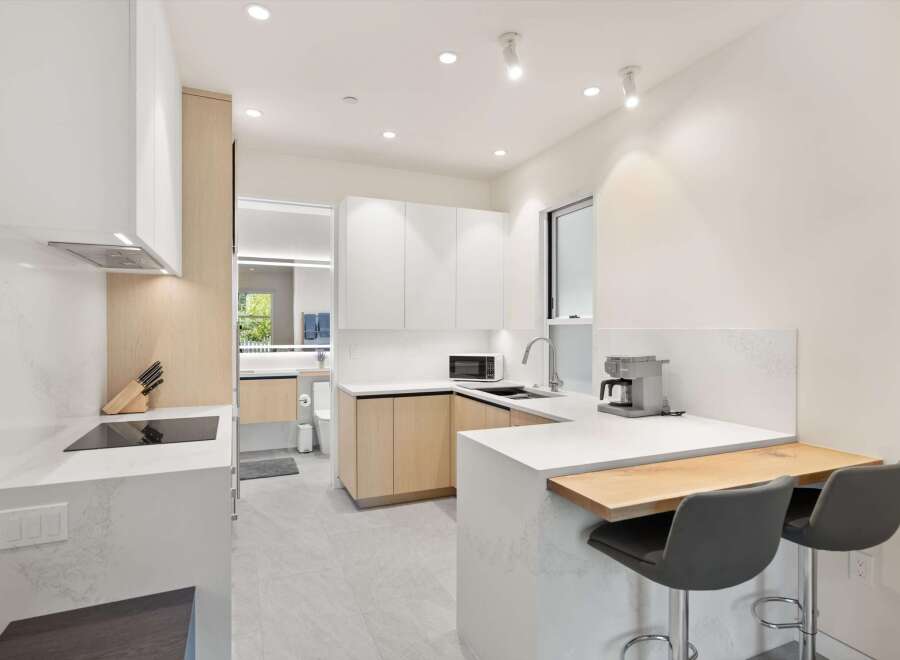 Modern kitchen with white cabinets and quartz countertops.