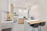 Modern kitchen with white cabinets and quartz countertops.