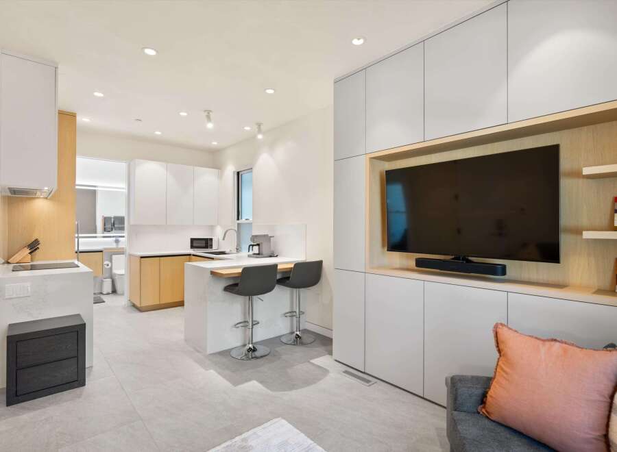 Modern kitchen and living area with integrated cabinetry and sleek appliances.