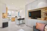 Modern kitchen and living area with integrated cabinetry and sleek appliances.
