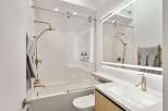 This stunning bathroom boasts a modern design with sleek gold fixtures and a frameless glass shower enclosure.