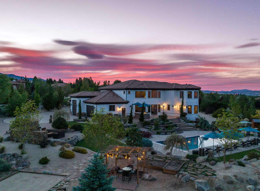Luxury estate boasting a stunning sunset view, expansive backyard oasis with a pool and pergola, and meticulously landscaped grounds.