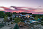 Luxury estate boasting a stunning sunset view, expansive backyard oasis with a pool and pergola, and meticulously landscaped grounds.