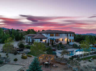Luxury estate boasting a stunning sunset view, expansive backyard oasis with a pool and pergola, and meticulously landscaped grounds.