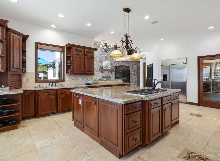 This stunning kitchen boasts a large island with granite countertops and a gas cooktop, perfect for entertaining.