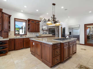 This stunning kitchen boasts a large island with granite countertops and a gas cooktop, perfect for entertaining.